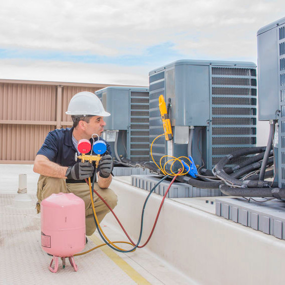 An HVAC tech charging rooftop units.