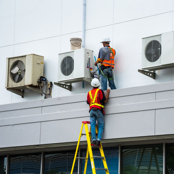 Two men checking out AC units.